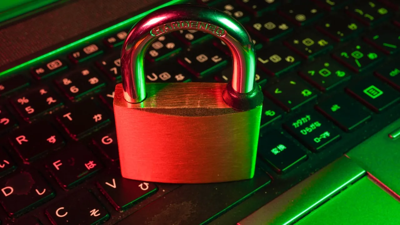 A small padlock resting on a keyboard lit by red and green ambient light — the visual shorthand for anonymous video chat privacy